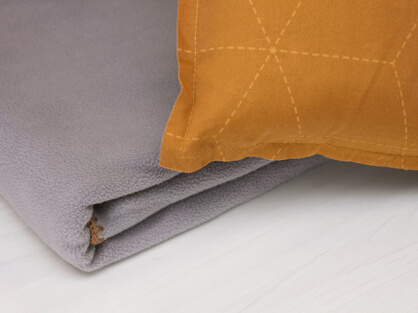 STARLUX Airlines' economy class eco-friendly blanket is made from oyster shell yarn and PET bottles. The picture also shows the pillow.