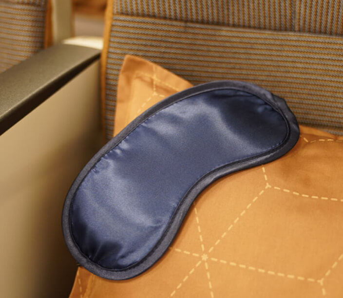 STARLUX Airlines economy class seat, pillow, and travel eye mask.